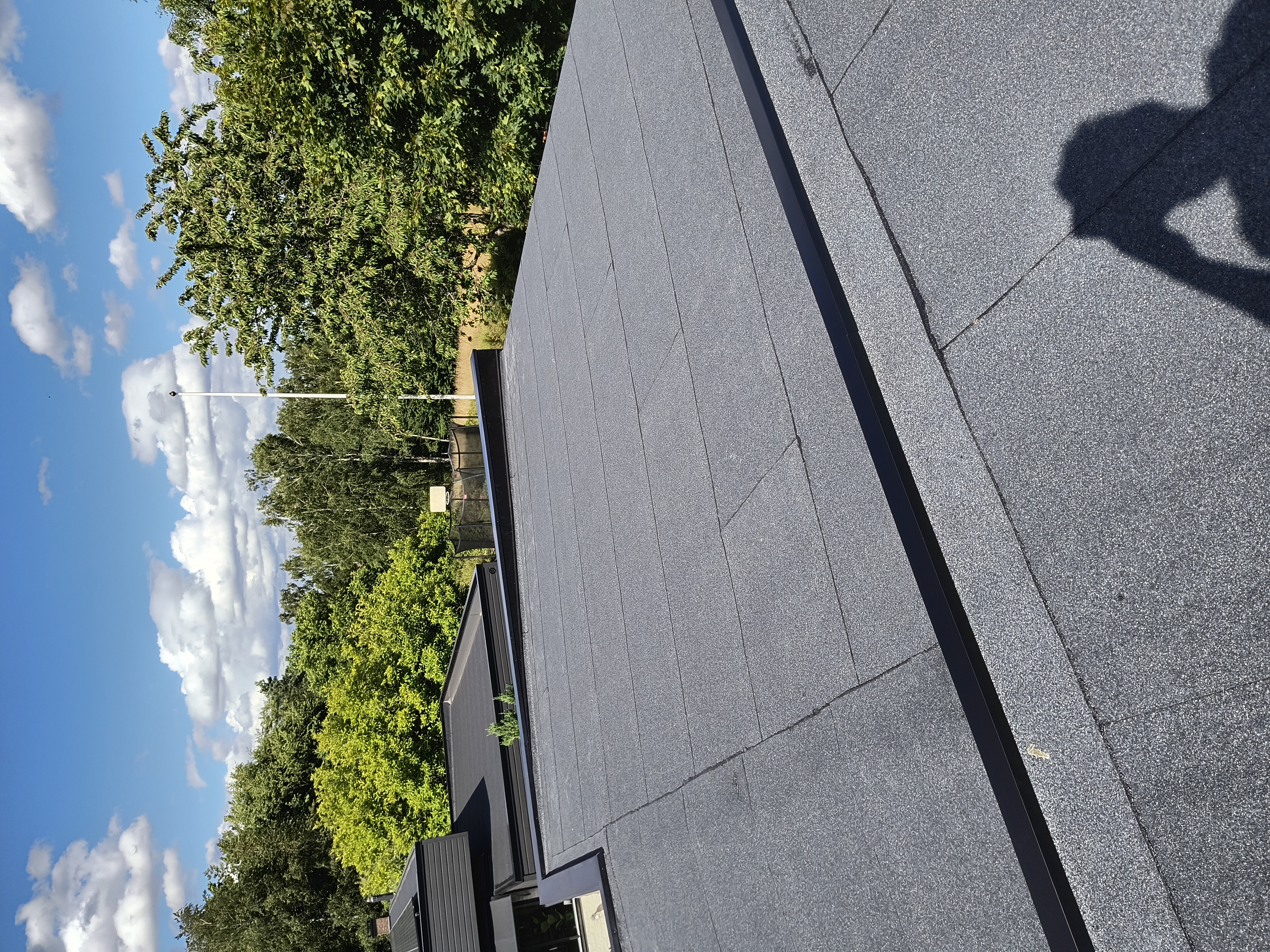 Läggning av nytt papptak på ett bostadshus för ett långsiktigt skydd mot väder och vind.