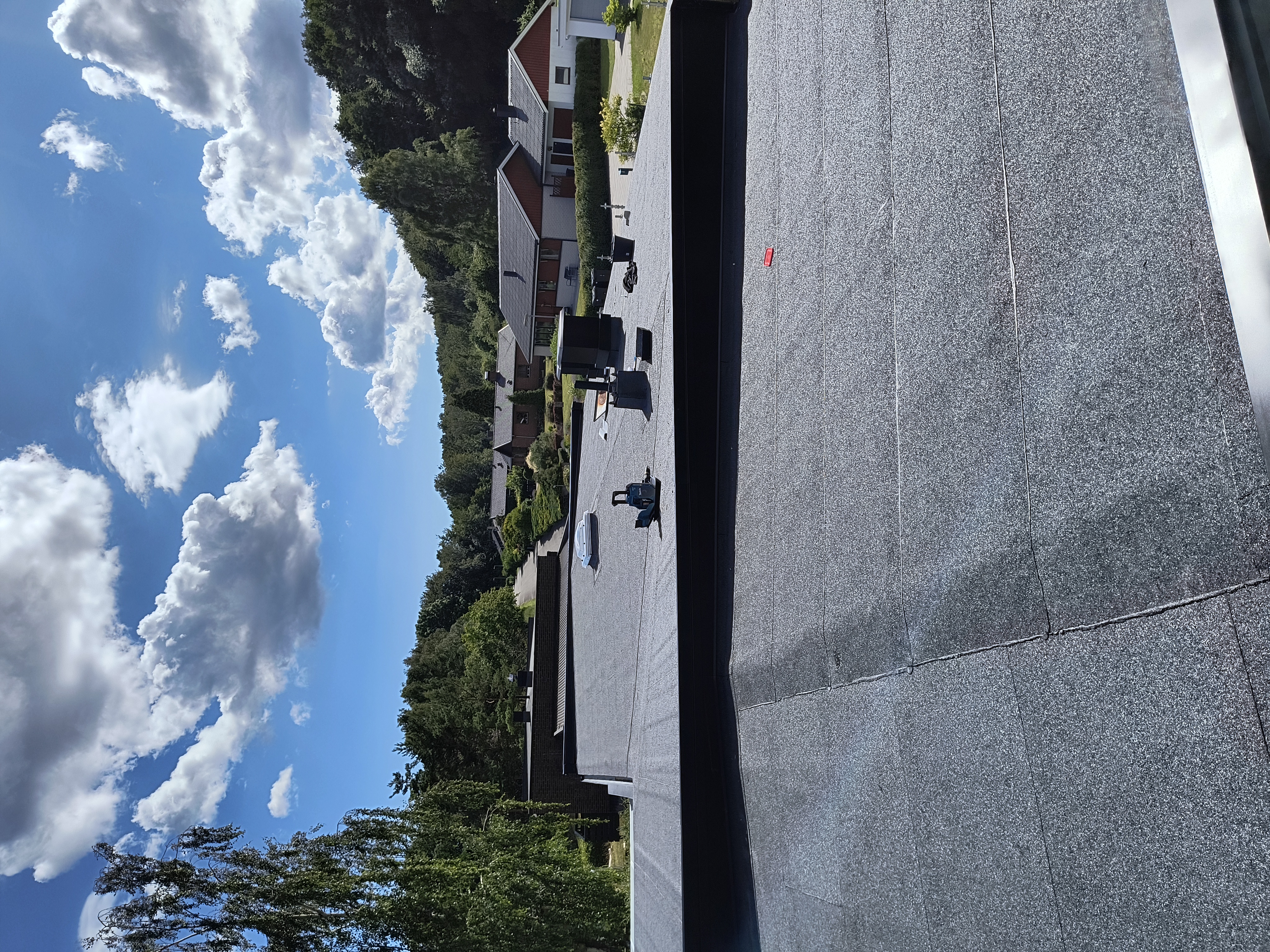 Läggning av nytt papptak på ett bostadshus för ett långsiktigt skydd mot väder och vind.