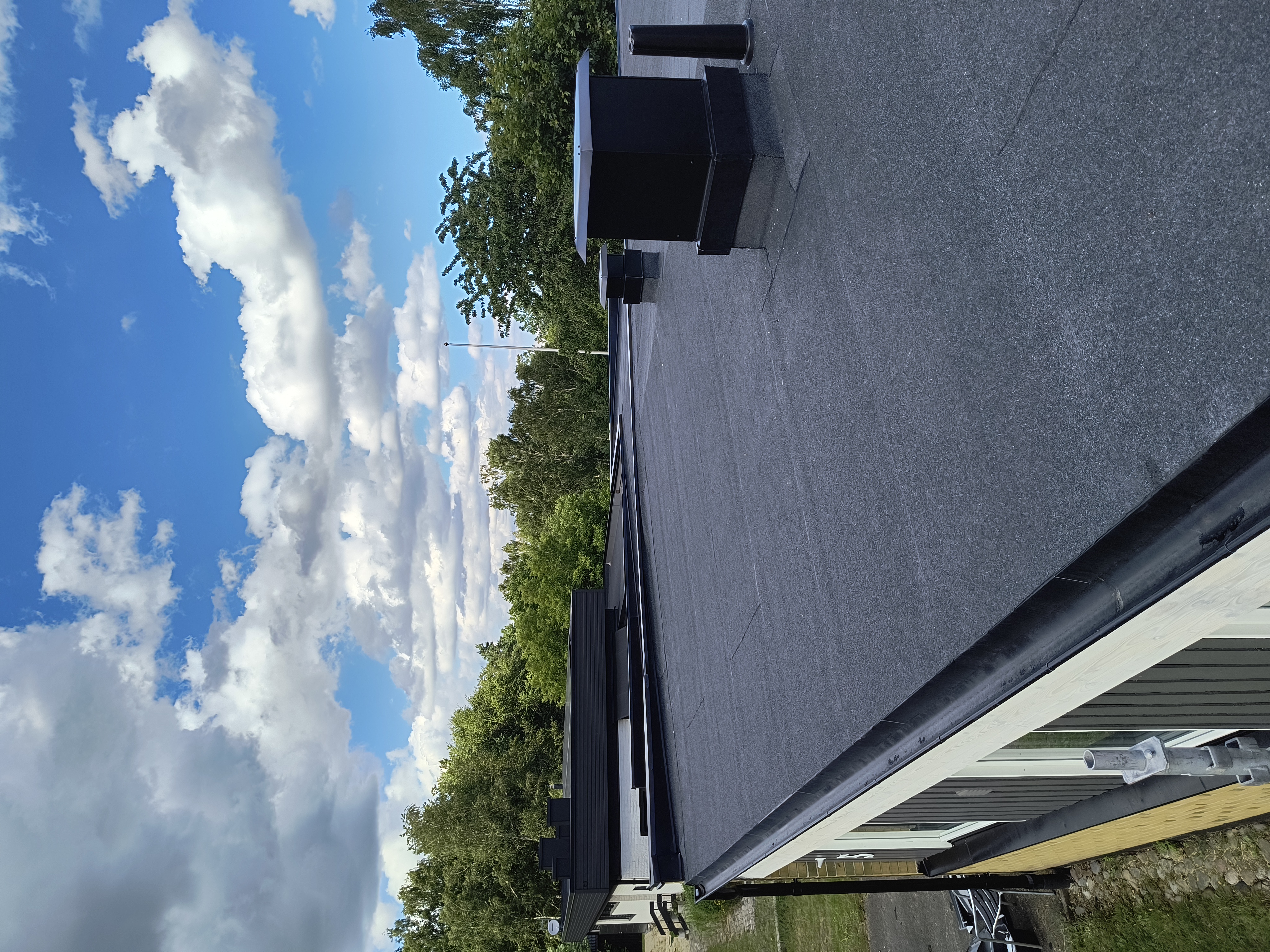 Läggning av nytt papptak på ett bostadshus för ett långsiktigt skydd mot väder och vind.