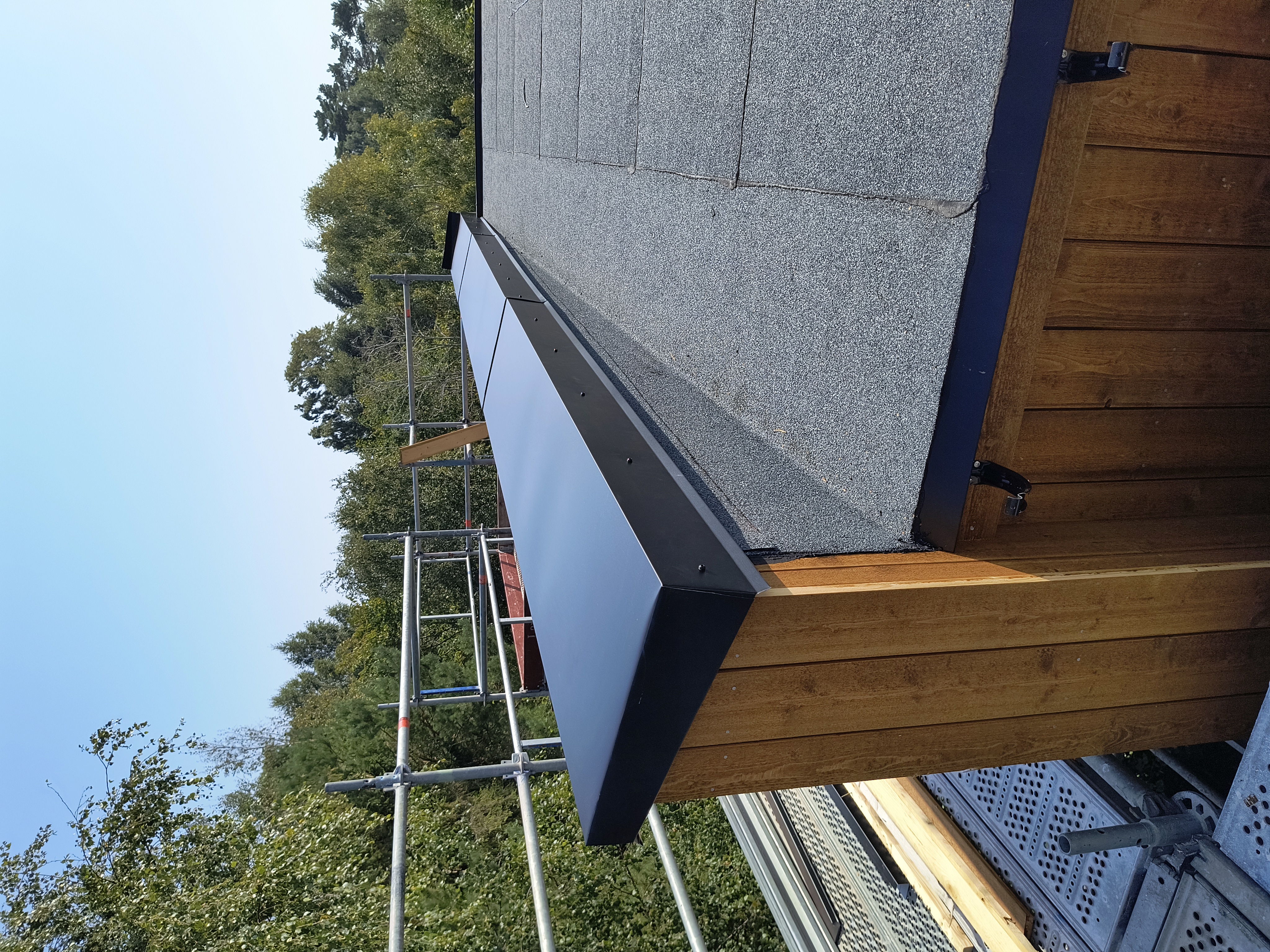 Erfaren plåtslagare som arbetar på ett tegeltak i Skåne