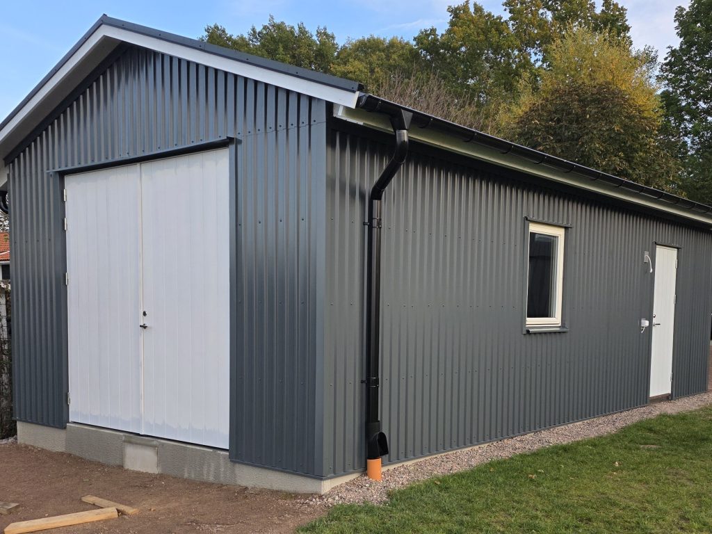 Garage med ny fasad i mörkgrå profilerad plåt
