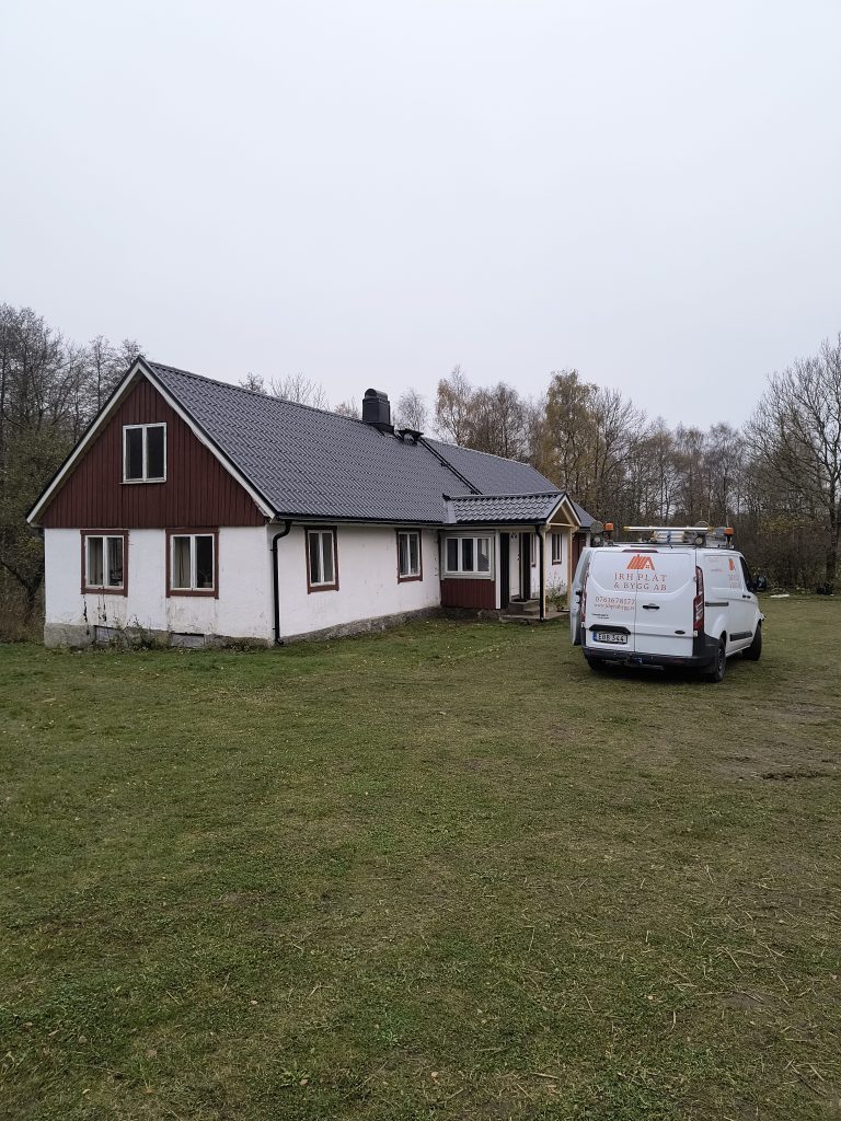 Villa med vit fasad och nytt svart tak