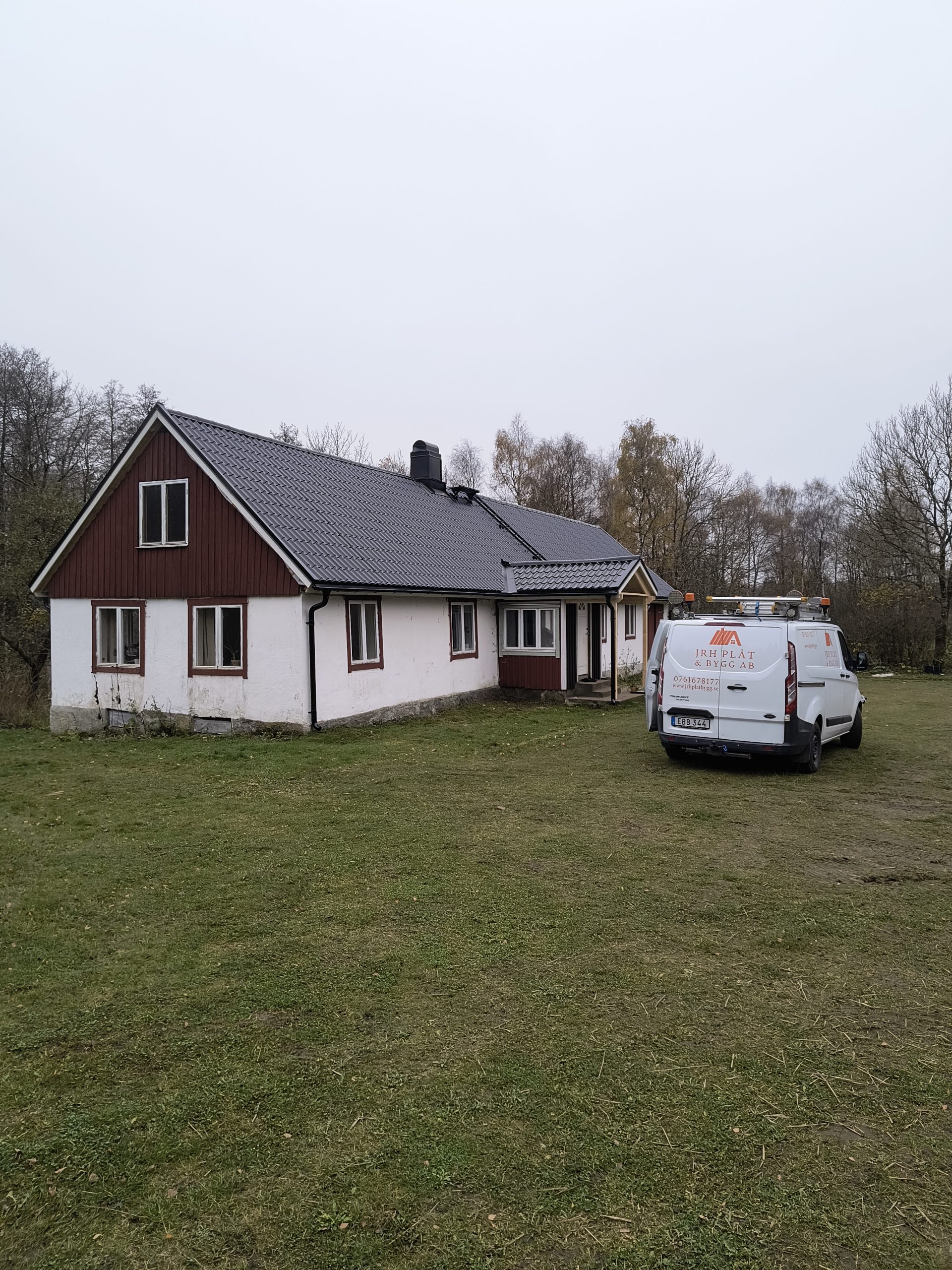 Villa med nytt svart tak och JRH Plåt & Bygg firmabil